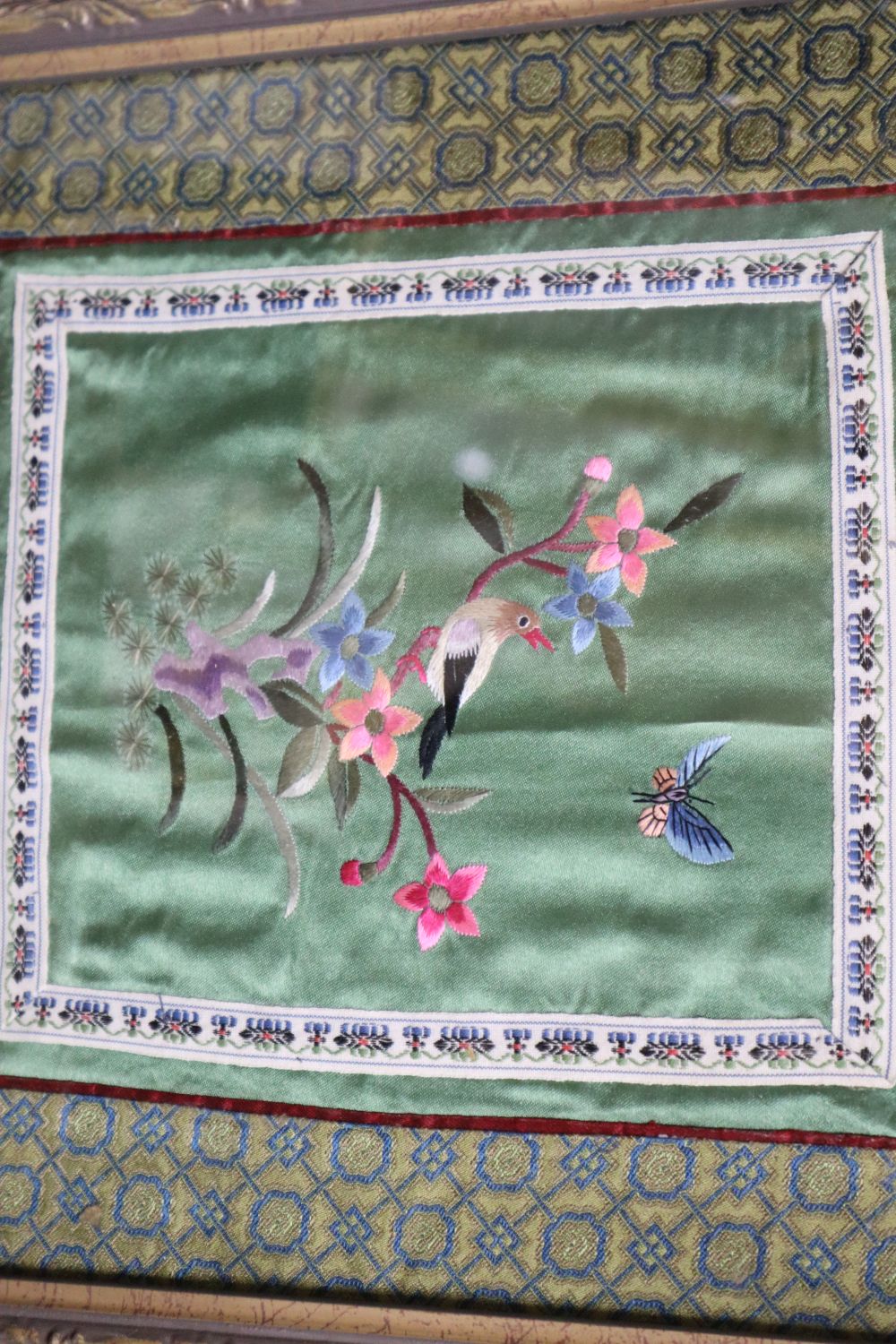 Eight Chinese embroidered silk panels, framed and glazed